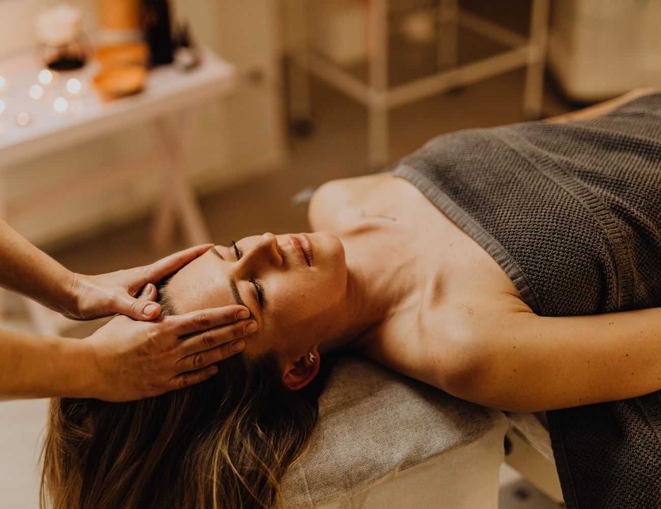 Woman receiving a relaxing head massage at a spa.