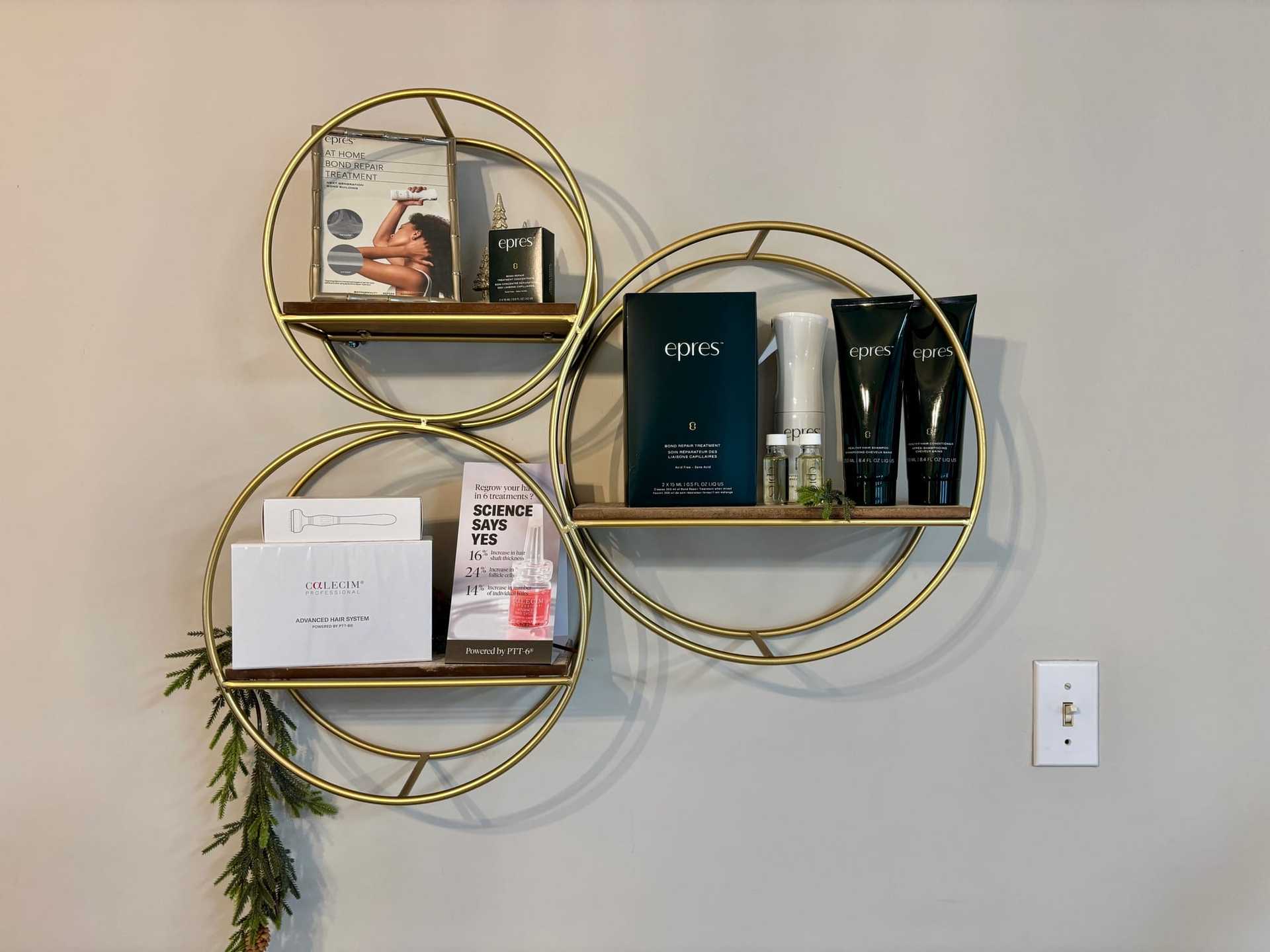 Skincare products and packages displayed on circular, golden wall shelves.