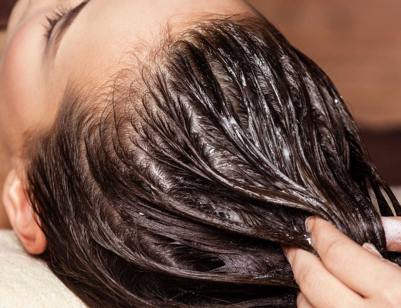 Hair being massaged with conditioner during a treatment.