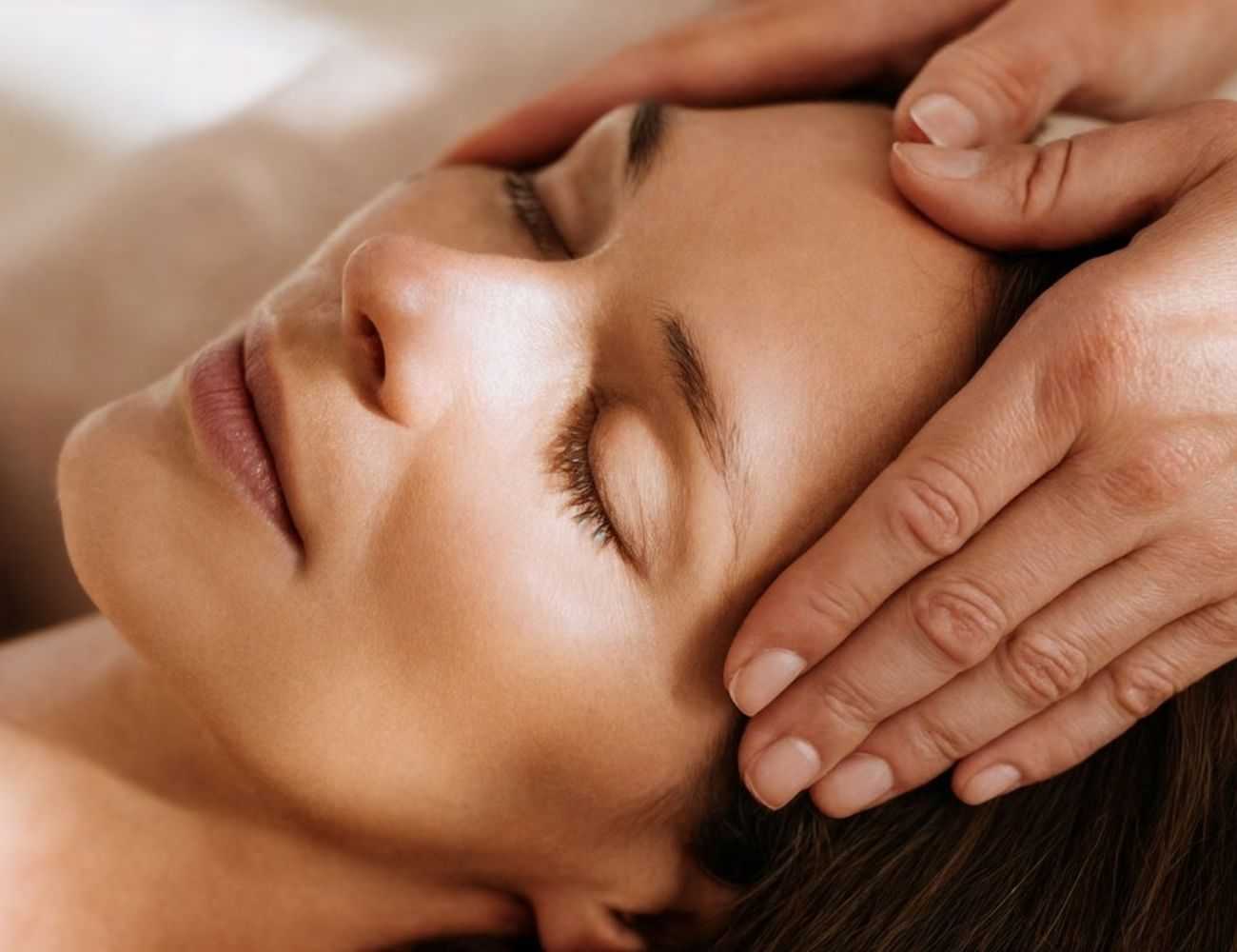 Relaxing head massage on a serene, closed-eyed woman.